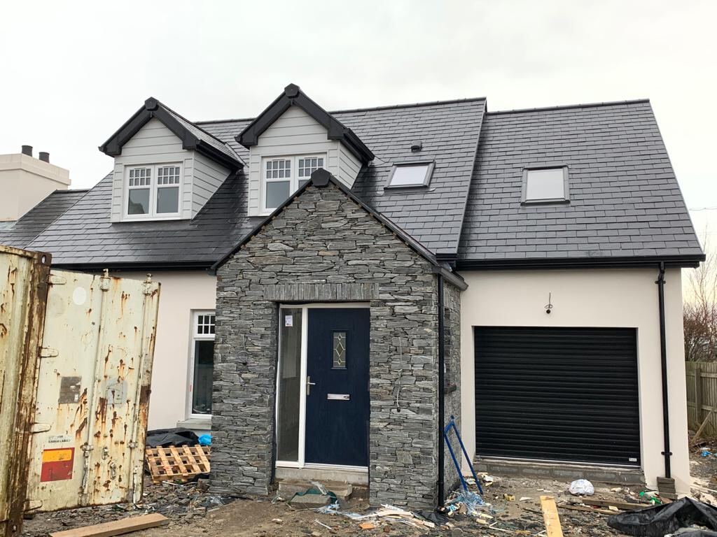 Completed new build with a stone front, slate roof and dormer windows