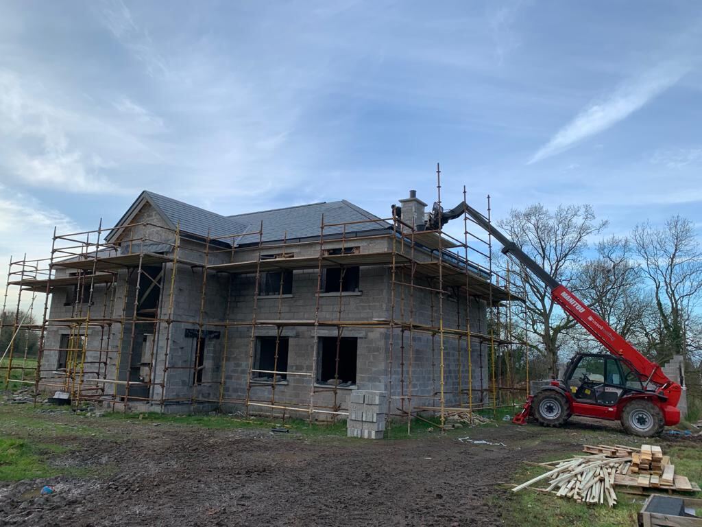 New build under scaffolding with a Russell Roofing telehandler
