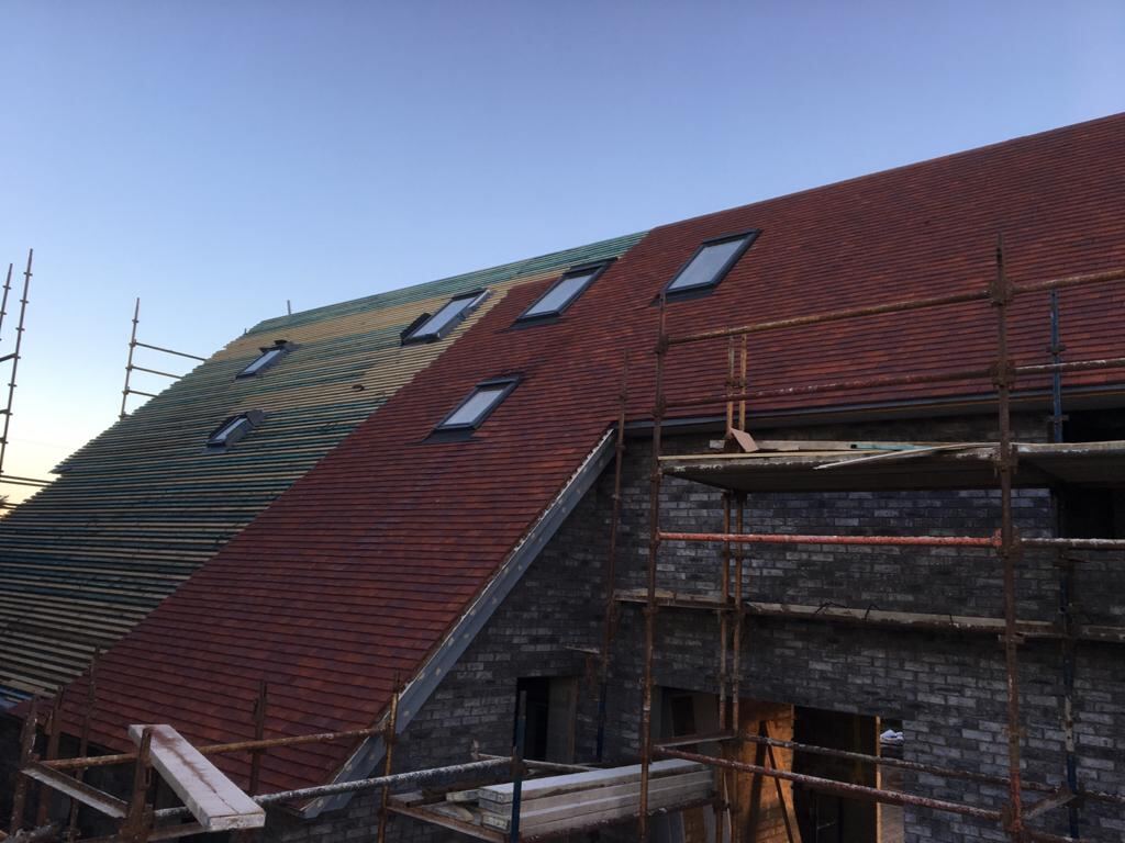 Red tiled roof with roof windows during works