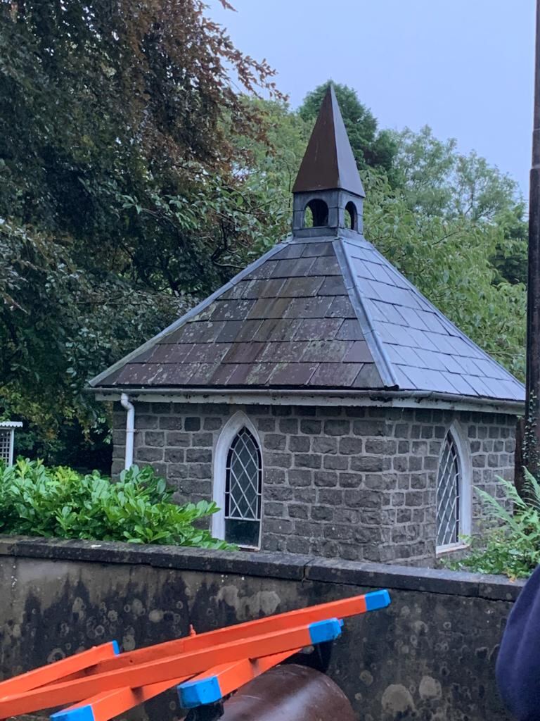 Stone chapel with a slate roof and bell tower
